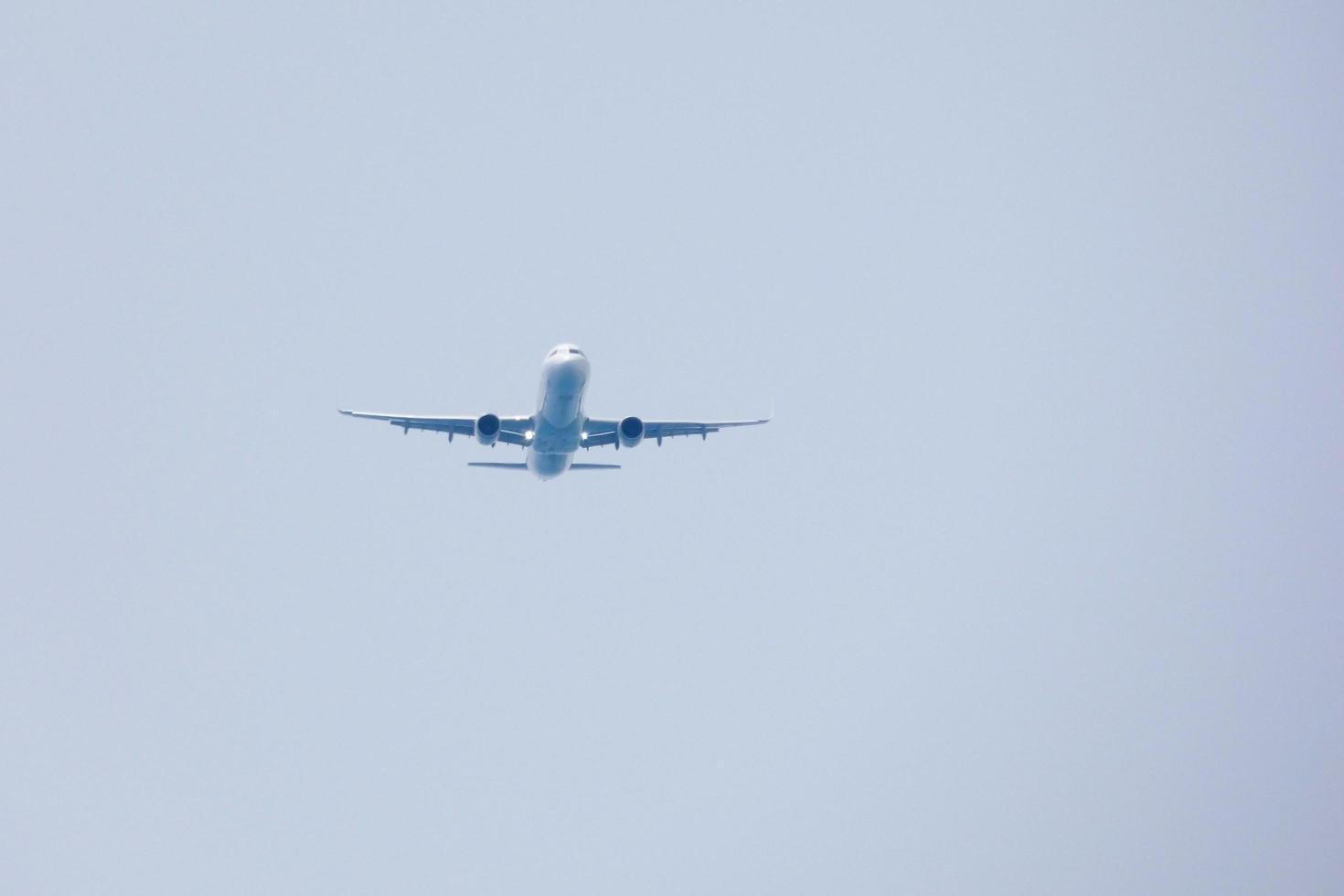 aeronaves comerciais voando sob céu azul e chegando ao aeroporto foto