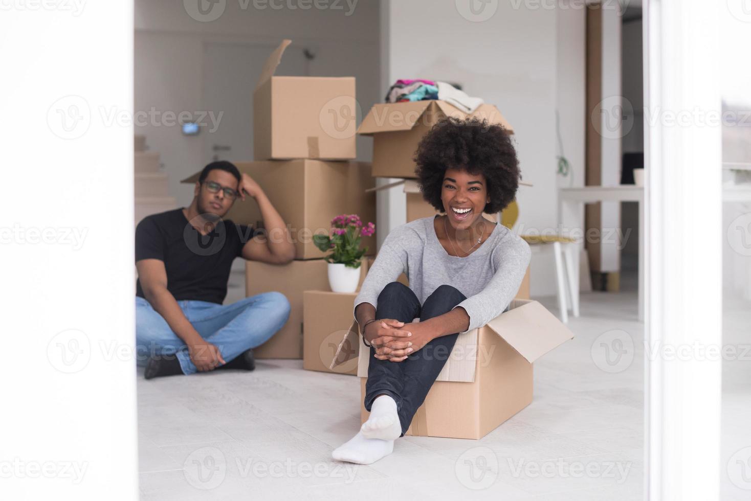 casal afro-americano brincando com material de embalagem foto