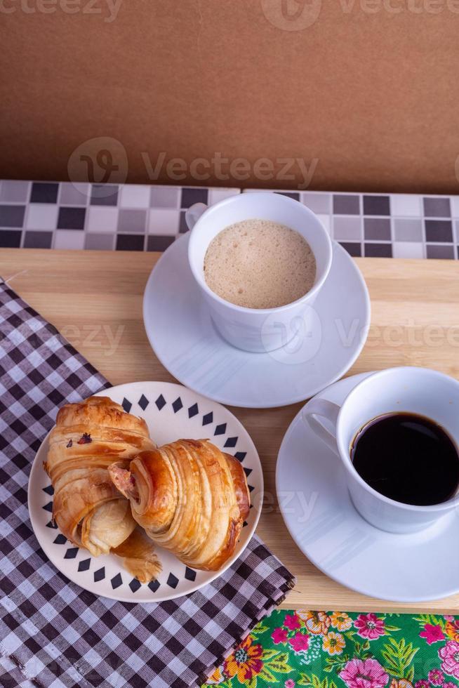 xícara de café e croissant foto