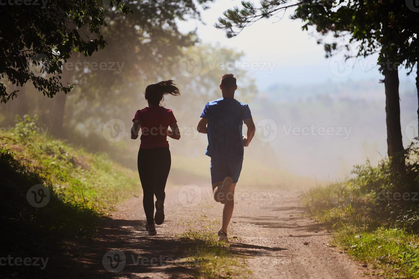 casal desfrutando de um estilo de vida saudável enquanto corre em uma estrada rural foto