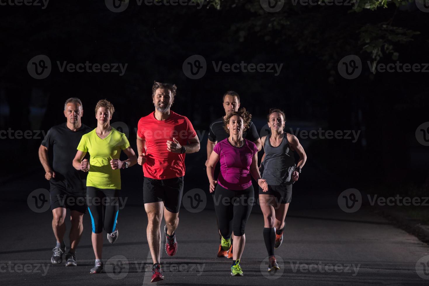 equipe de corredores no treinamento noturno foto