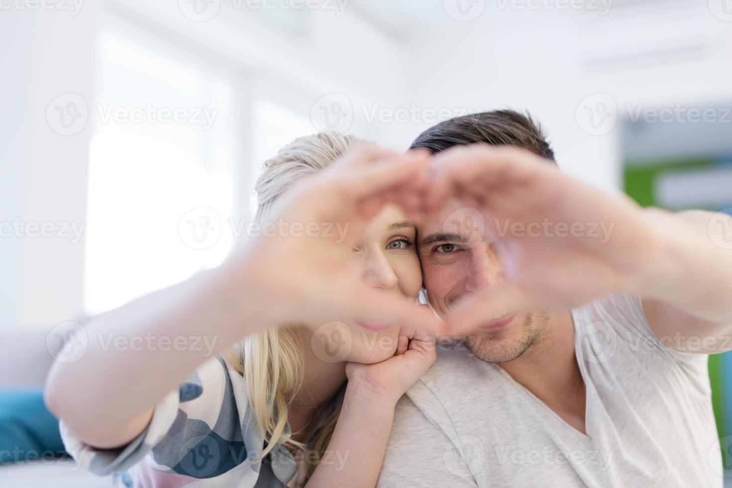 casal fazendo coração com as mãos foto