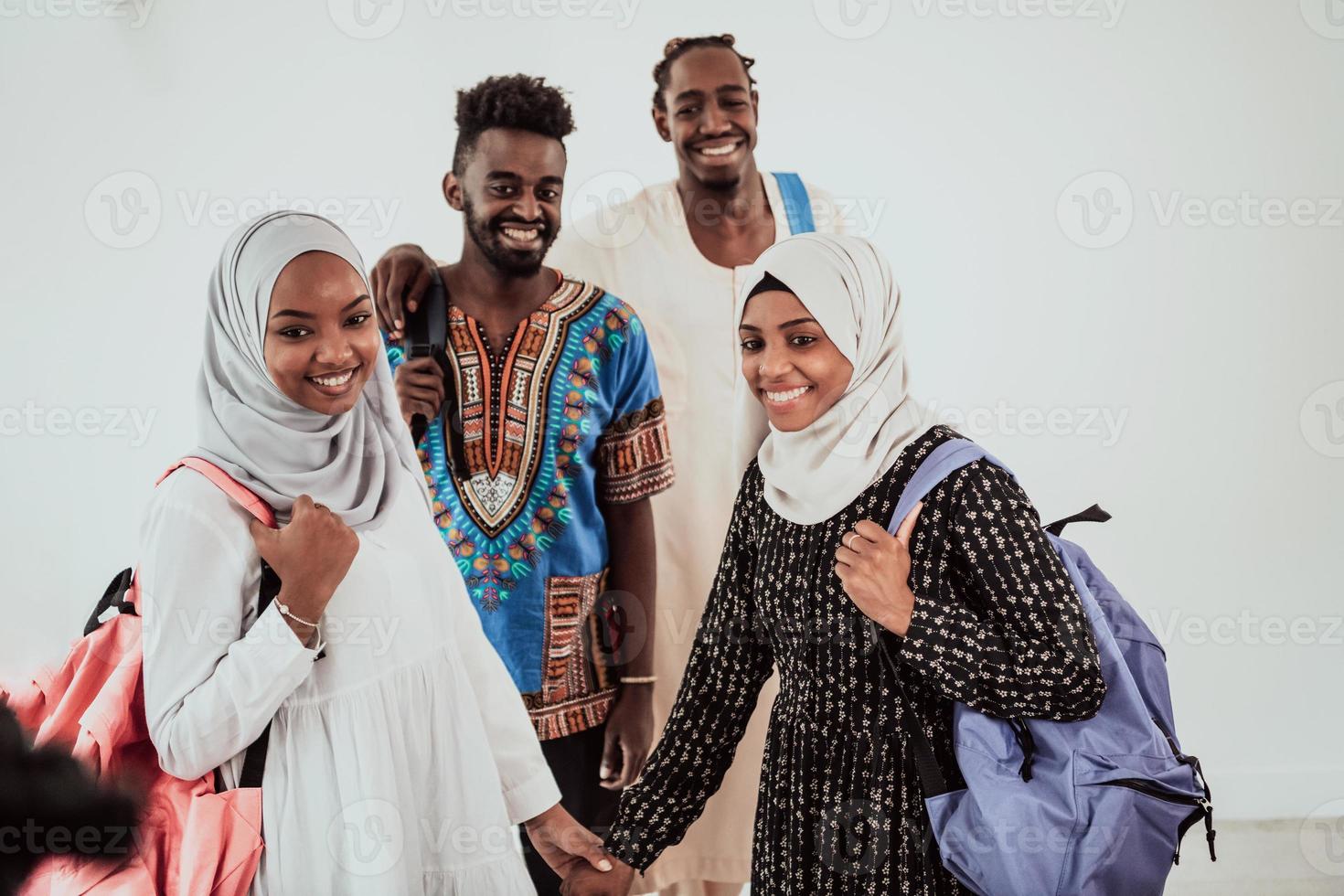 grupo de estudantes africanos felizes conversando e reunião de equipe trabalhando juntos em meninas de lição de casa vestindo moda hijab muçulmana do sudão traidiional foto