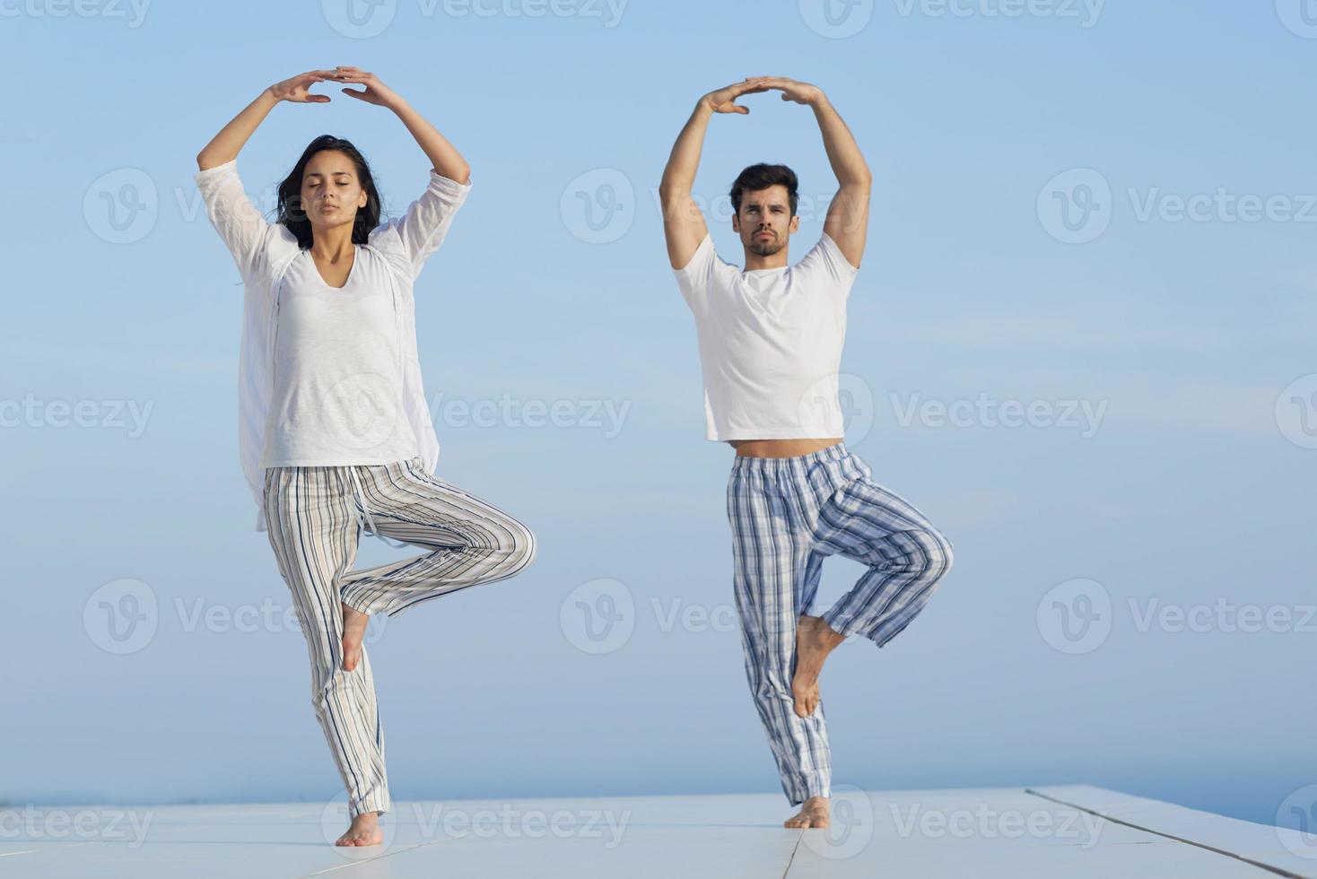 jovem casal praticando ioga foto