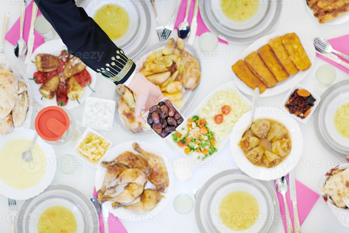 família muçulmana jantando iftar comendo datas para quebrar a vista superior da festa foto