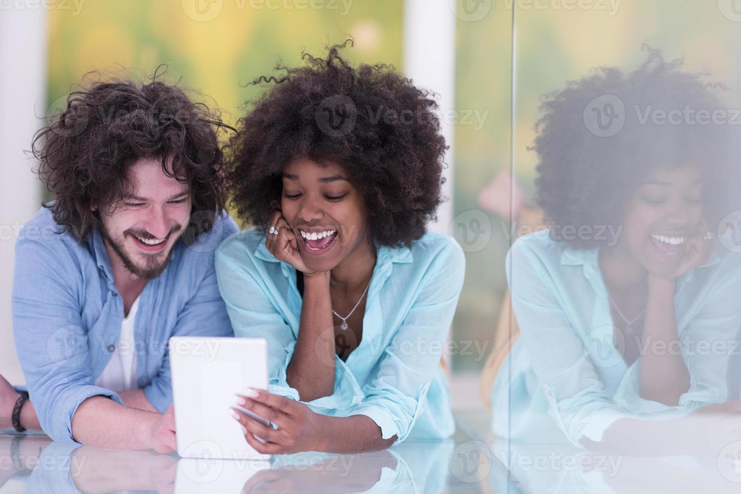 casal relaxando juntos em casa com computador tablet foto