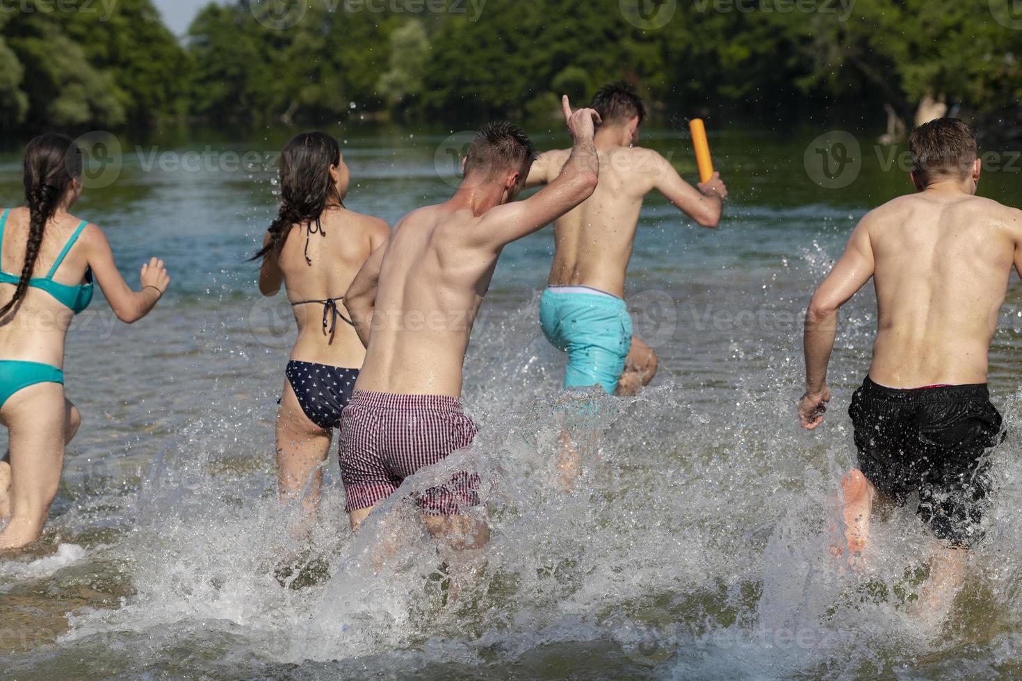 grupo de amigos felizes se divertindo no rio foto