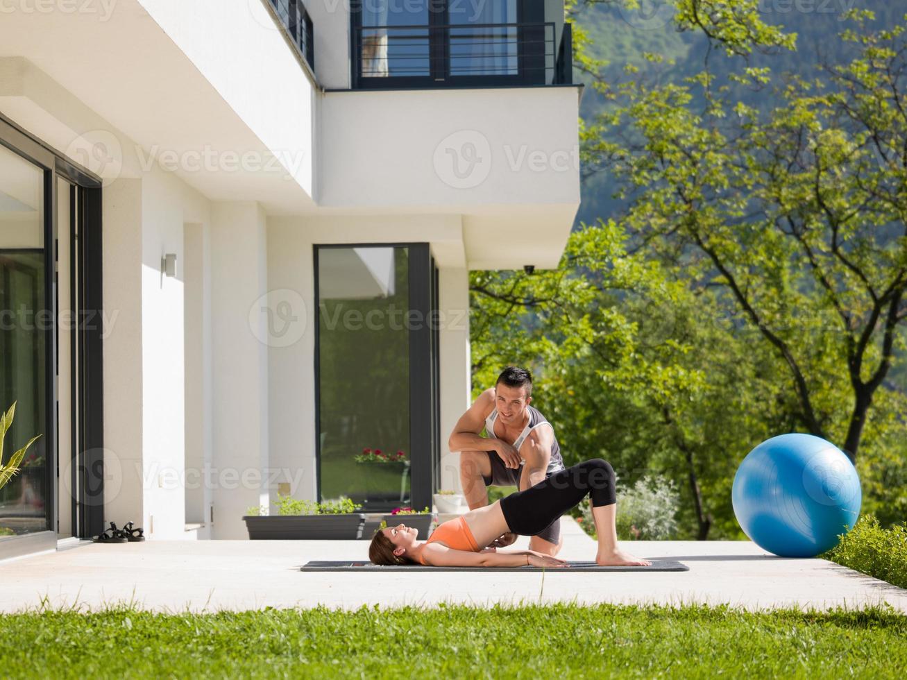 mulher com personal trainer fazendo exercícios de ioga matinais foto