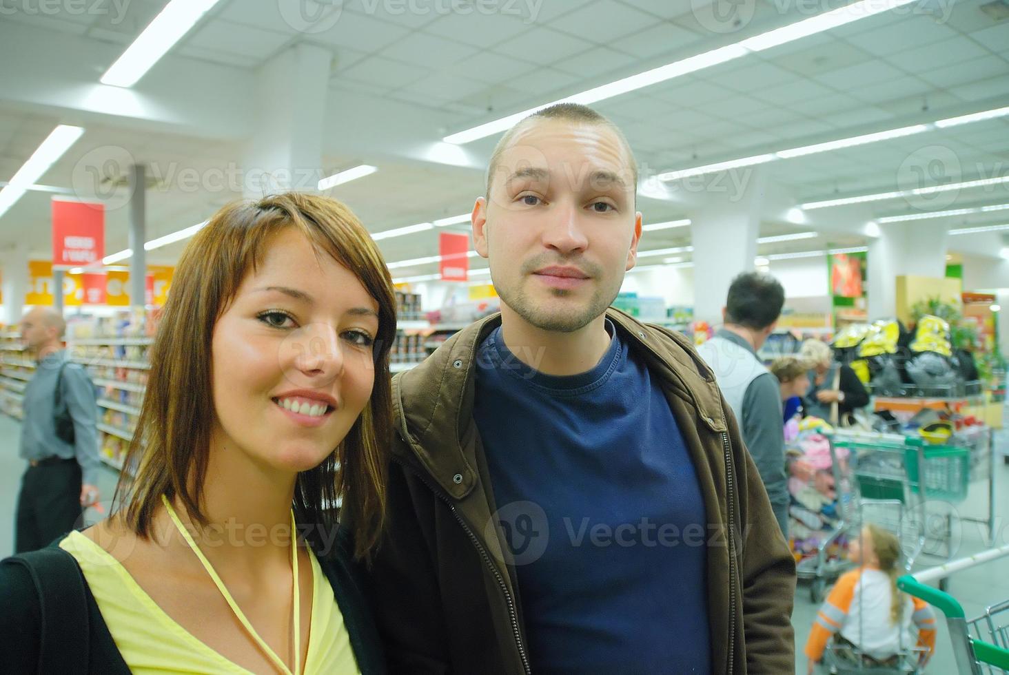 casal jovem feliz no supermercado foto