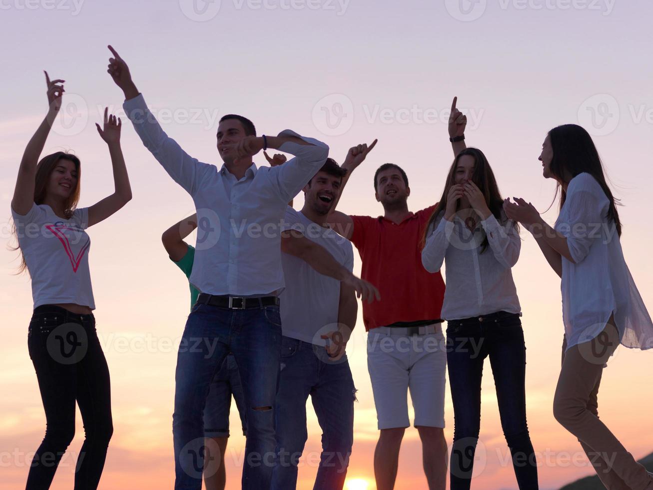 pessoas de festa no pôr do sol foto