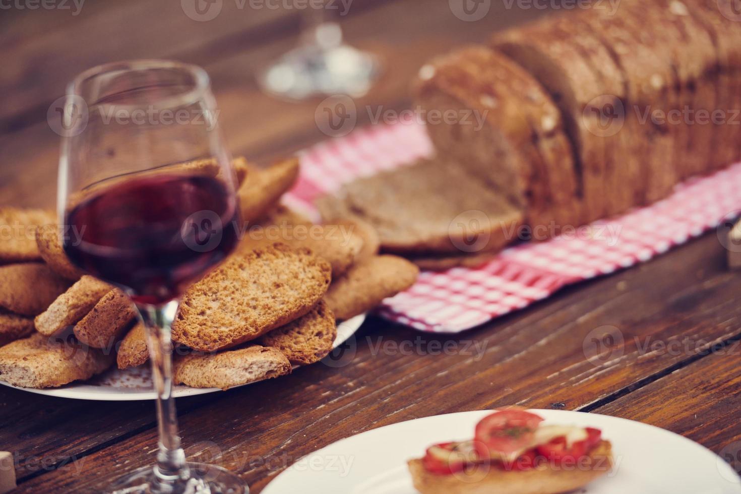 composição com um copo de vinho tinto e pão torrado foto