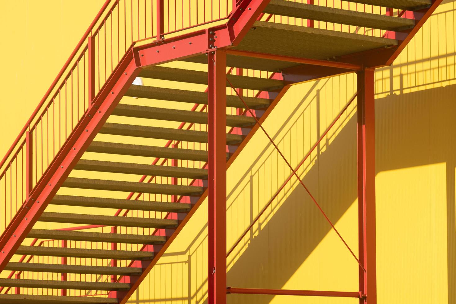 oberhausen, alemanha, 2022 - escada vermelha ao sol na parede amarela foto