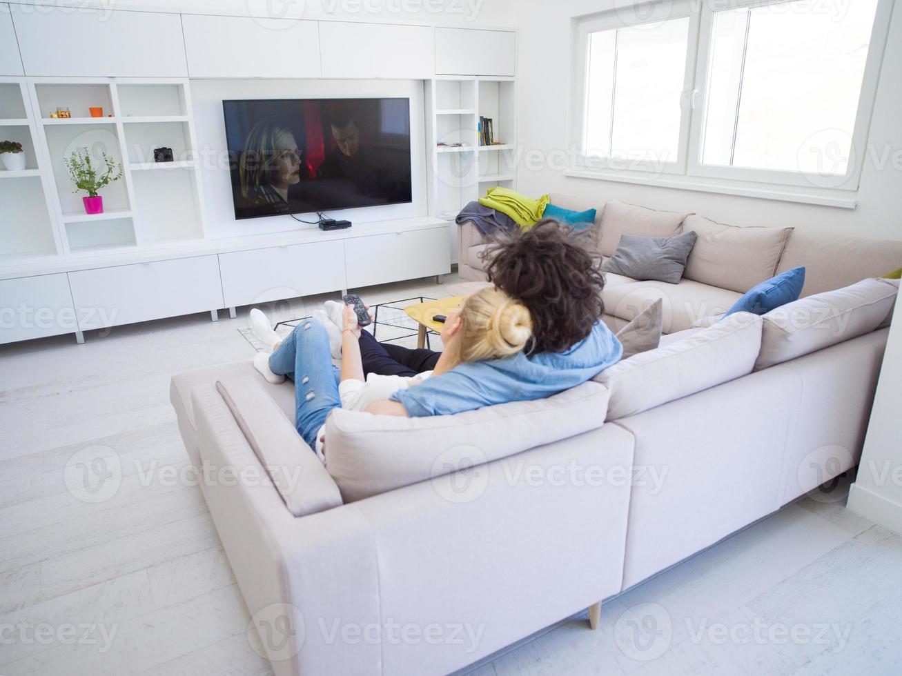 jovem casal no sofá assistindo televisão foto