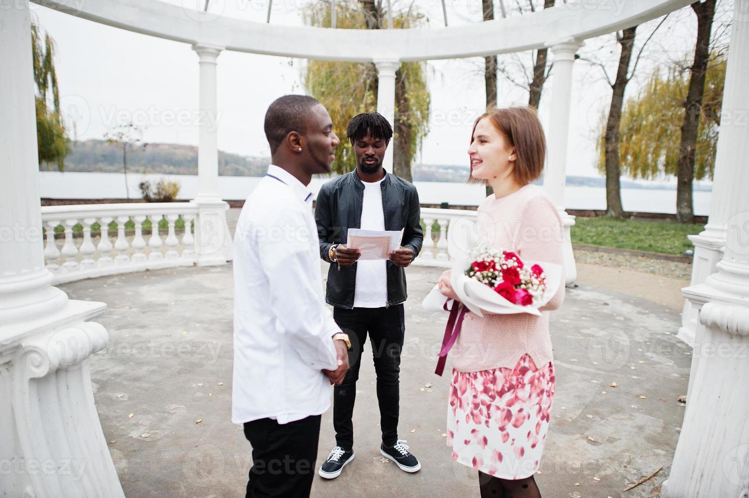 cerimônia de noivado de casamento com o pastor. feliz casal multiétnico na história de amor. relacionamentos de homem africano e mulher branca europeia. foto