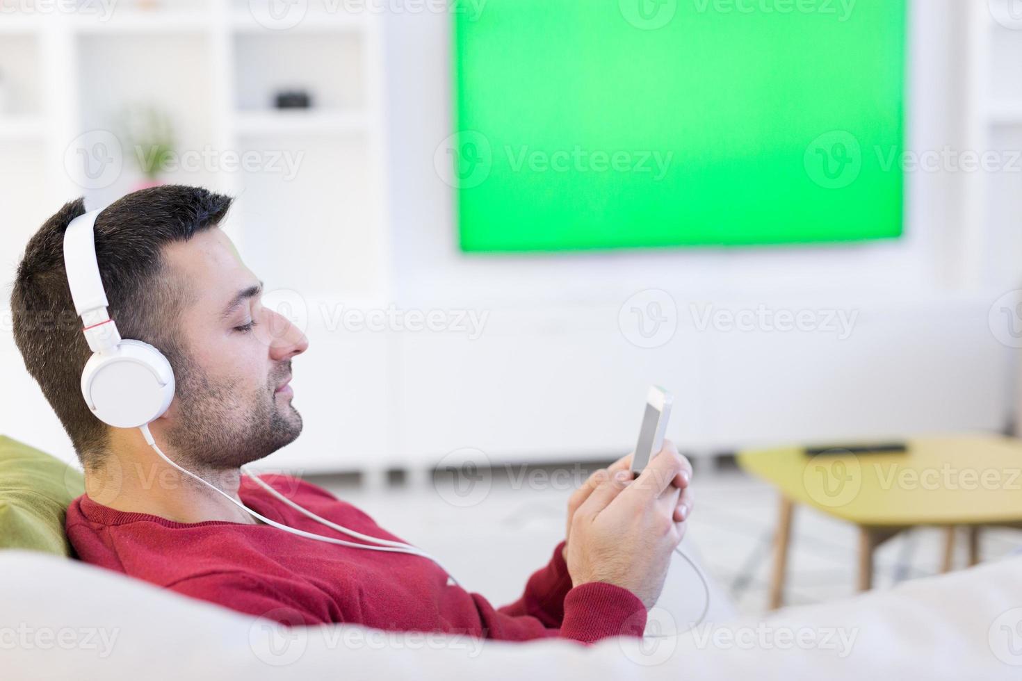 homem curtindo música através de fones de ouvido foto