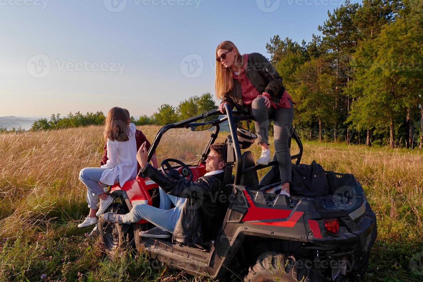 grupo jovens felizes desfrutando de um belo dia de sol enquanto dirigia um carro de buggy off road foto