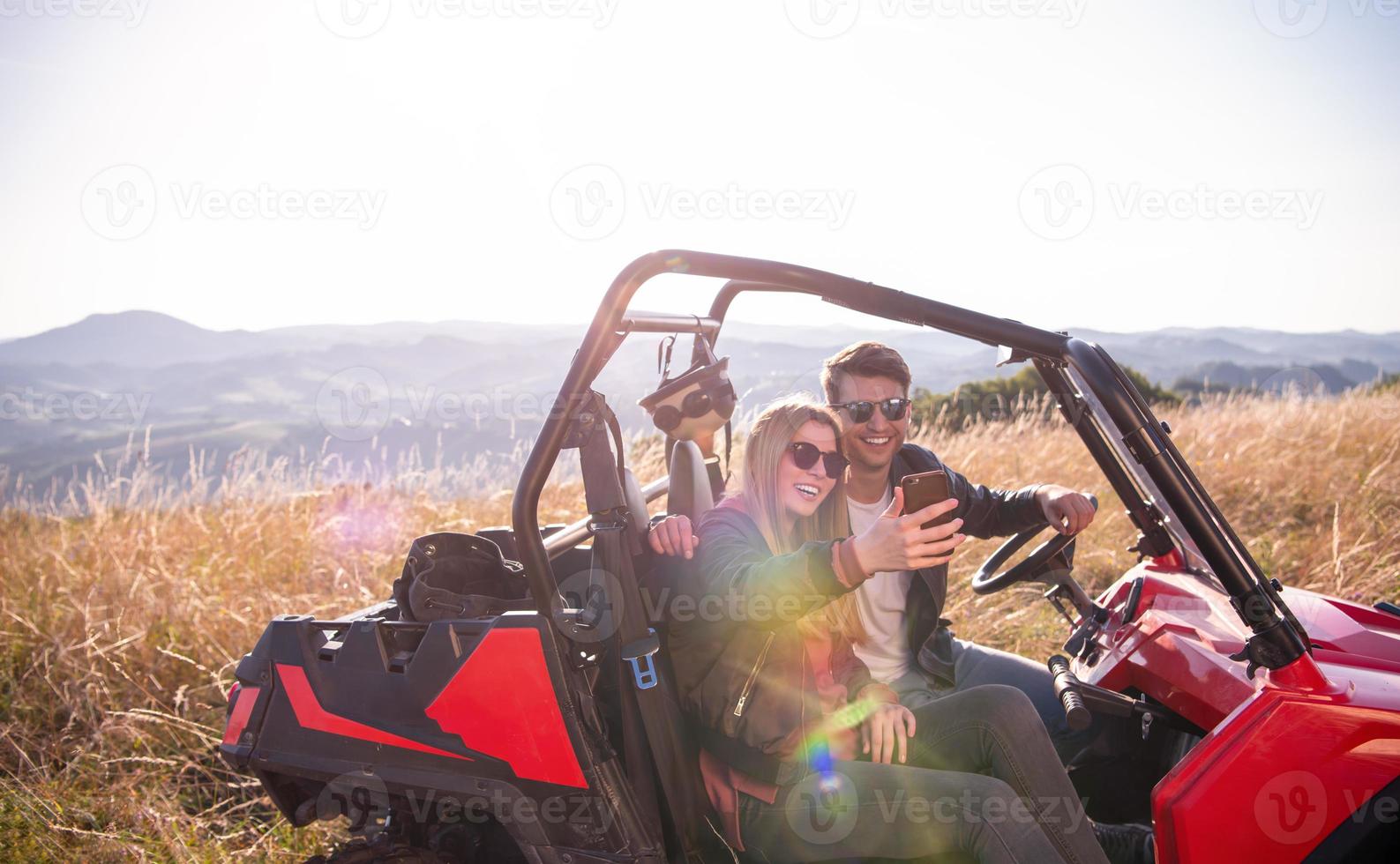 jovem casal tirando foto de selfie enquanto dirigia um buggy off road
