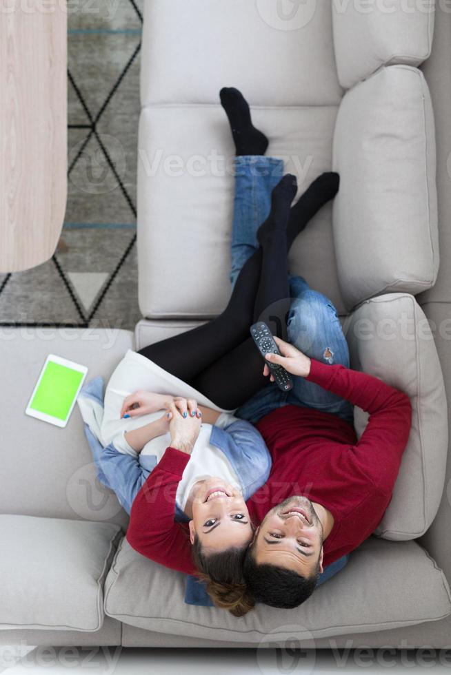 jovem casal no sofá assistindo televisão vista superior foto