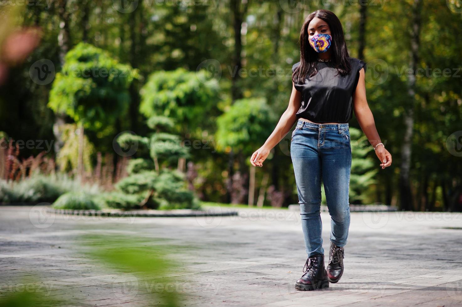 mulher afro-americana na moda, use máscara facial feita à mão posando ao ar livre. nova vida normal. foto