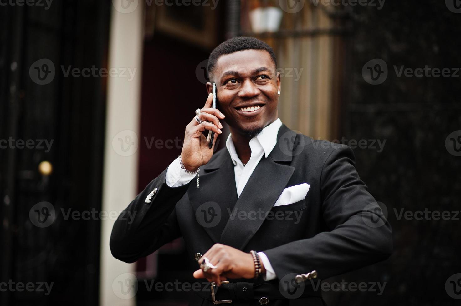 retrato de jovem e bonito empresário americano africano de terno falar no celular, prepare-se para a reunião. foto