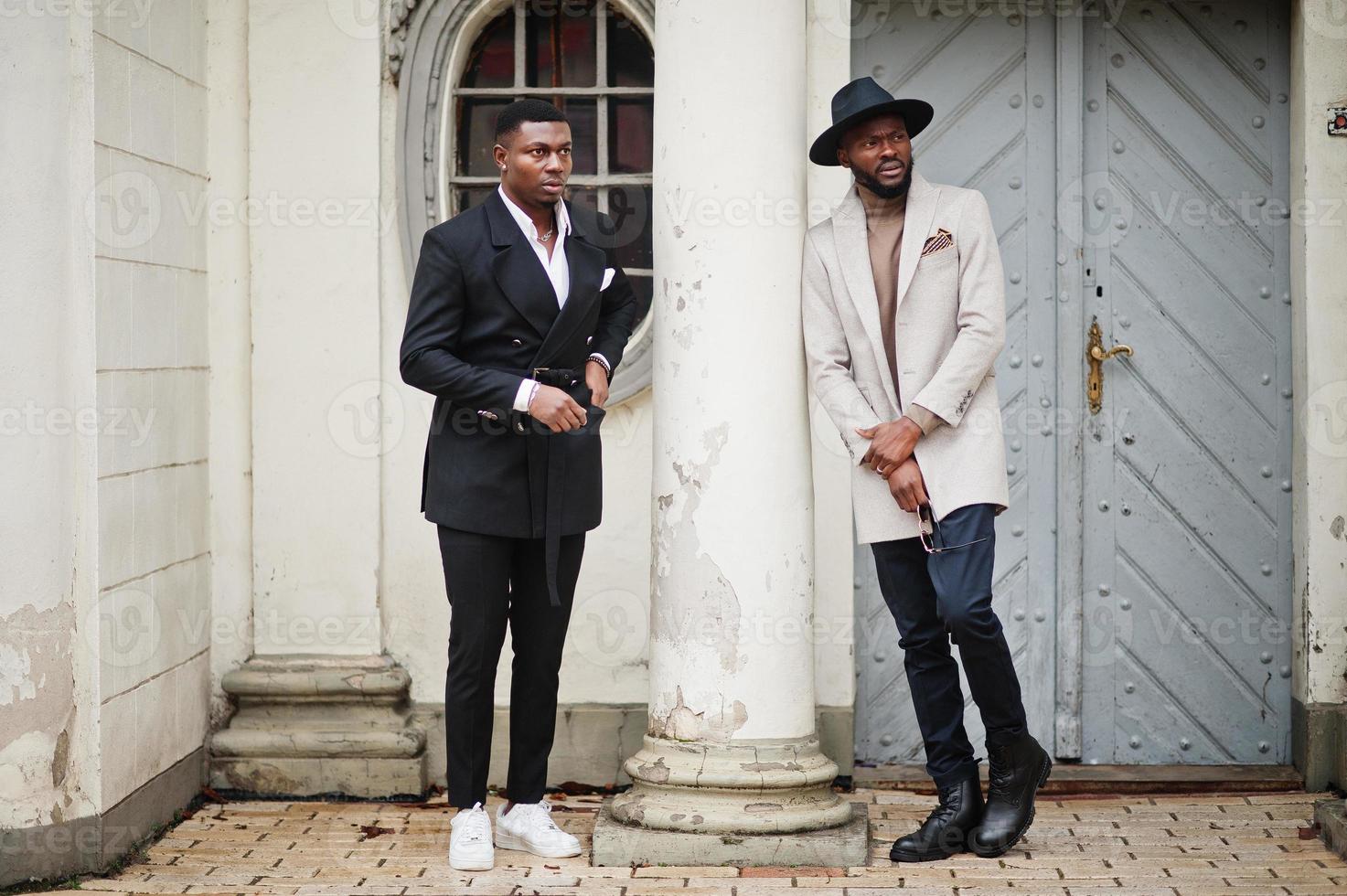 dois homens negros da moda. retrato elegante de modelos masculinos afro-americanos. usar terno, casaco e chapéu. foto
