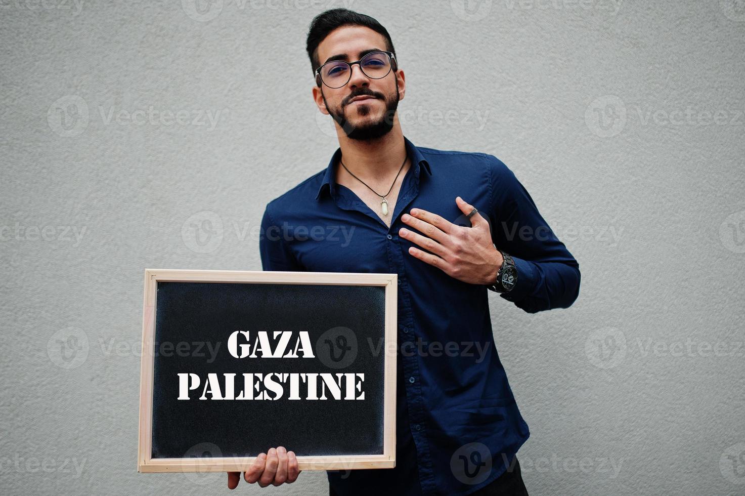 homem árabe usa camisa azul e óculos segura placa com inscrição em gaza palestina. maiores cidades no conceito do mundo islâmico. foto