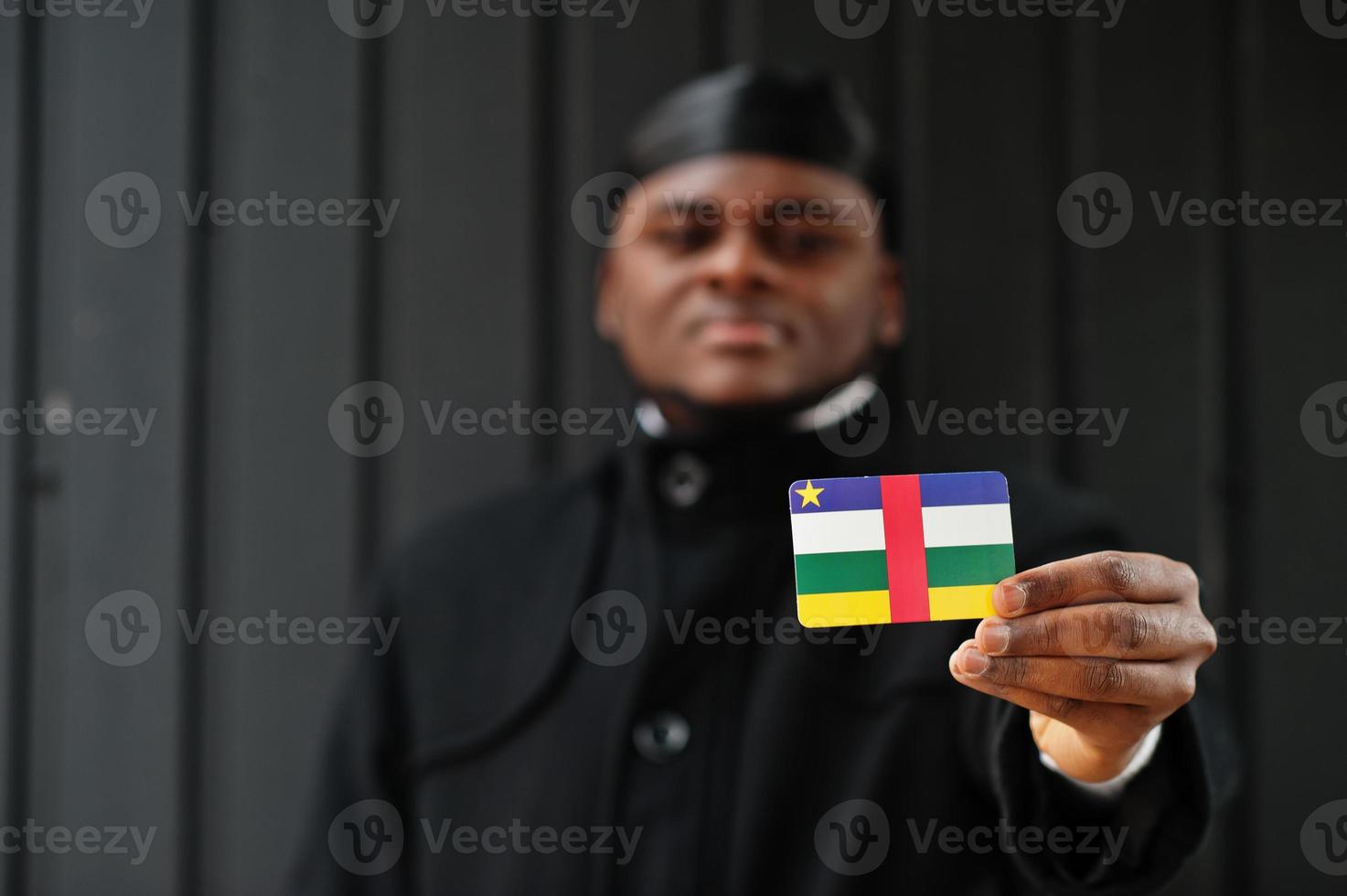 homem africano desgaste preto durag segure a bandeira da república da África Central à mão isolado fundo escuro. foto