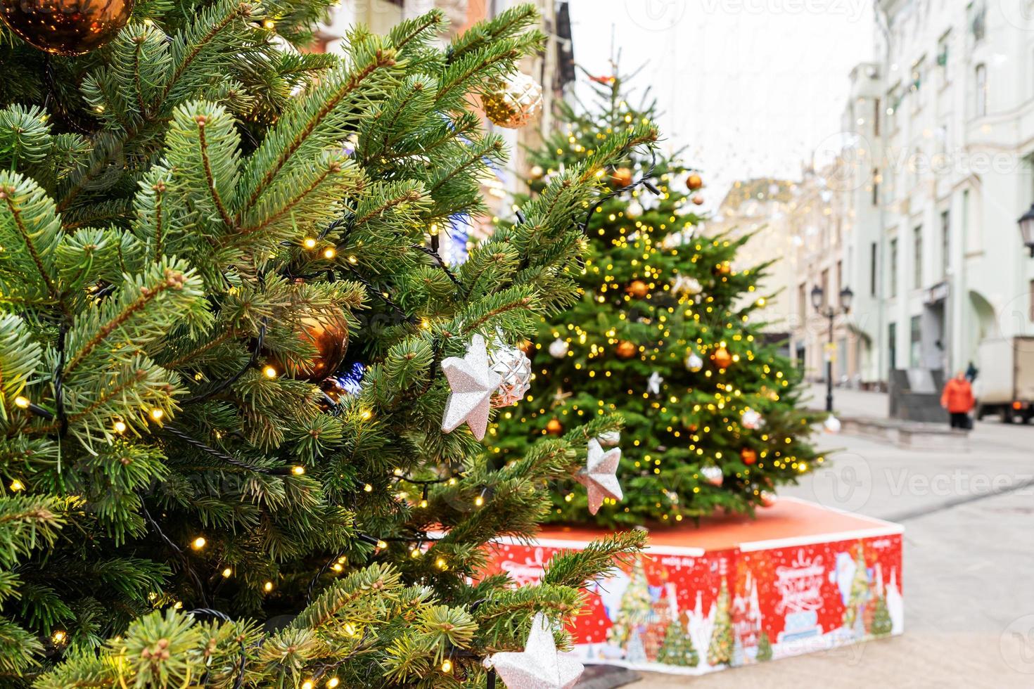 close-up de decoração de árvores de natal com brinquedos e guirlandas. decoração festiva da cidade durante as férias de inverno foto