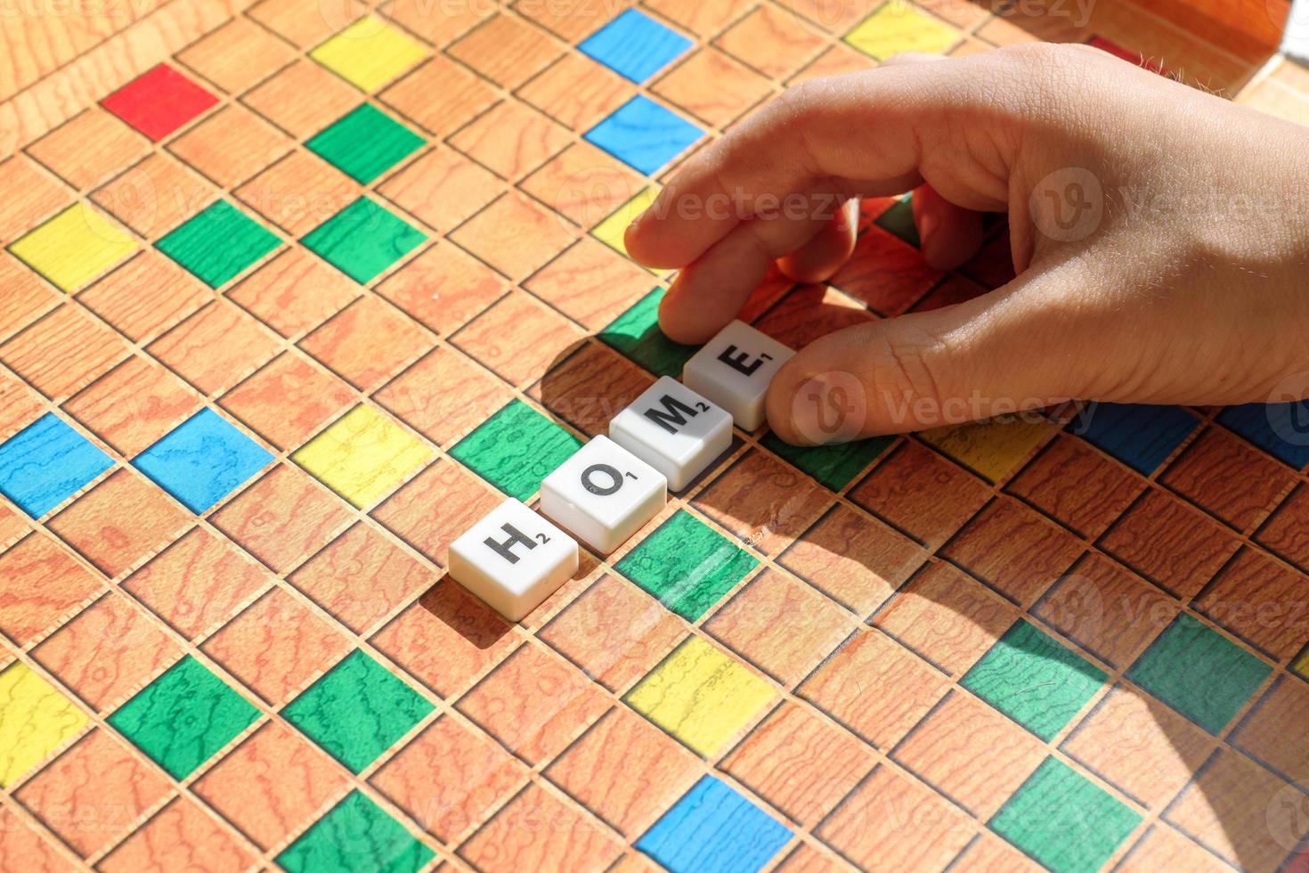 letras do jogo de scrabble. criança definir palavra em casa. conceito de educação e aprendizagem. foto