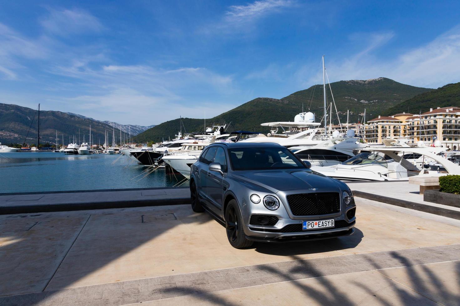 tivat, montenegro - 20 de outubro de 2020, carros bentley bentayga atracam em frente a um iate de luxo em uma marina na costa adriática. foto