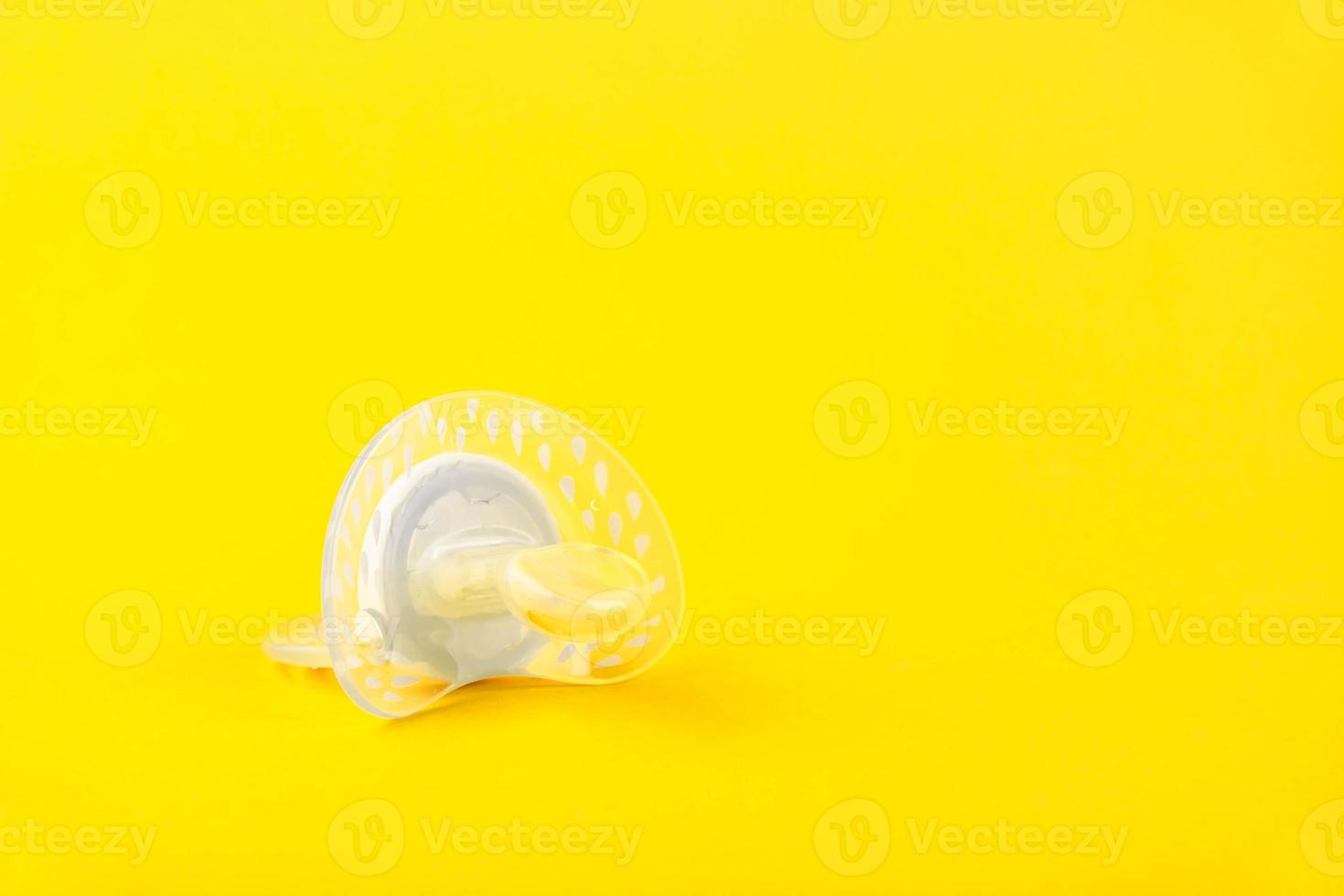 chupeta de silicone bebê branco sobre um fundo amarelo. copie o espaço. foto