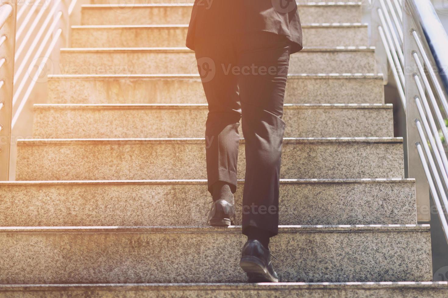feche os sapatos das pernas do jovem empresário uma pessoa andando subindo as escadas na cidade moderna, suba, sucesso, cresça. com efeito quente vintage retrô de tons de filtro. escada foto