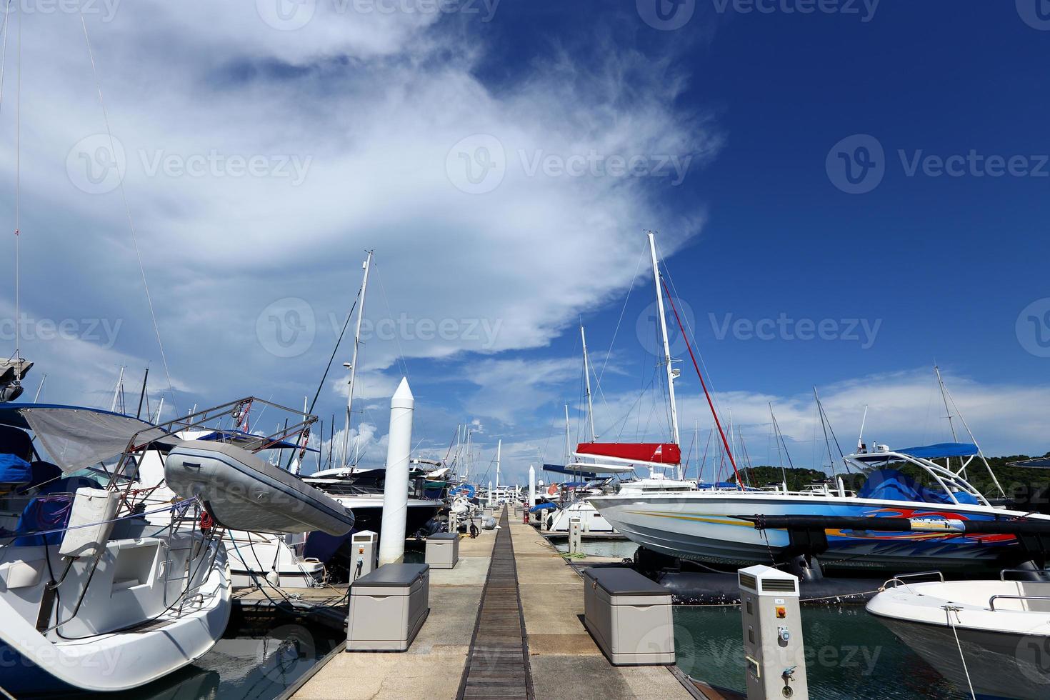 muitos iates de luxo flutuam no mar cristalino no clube marina bay, barco privado caro fica calmo no cais de ancoragem sob o céu azul de verão oceano verde foto