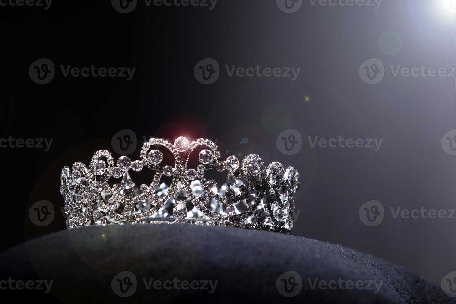 coroa de prata de diamante para concurso de beleza de concurso de miss, joias de tiara de cristal decoradas com pedras preciosas e fundo escuro abstrato em tecido de veludo preto, espaço de cópia de macro fotografia para logotipo de texto foto