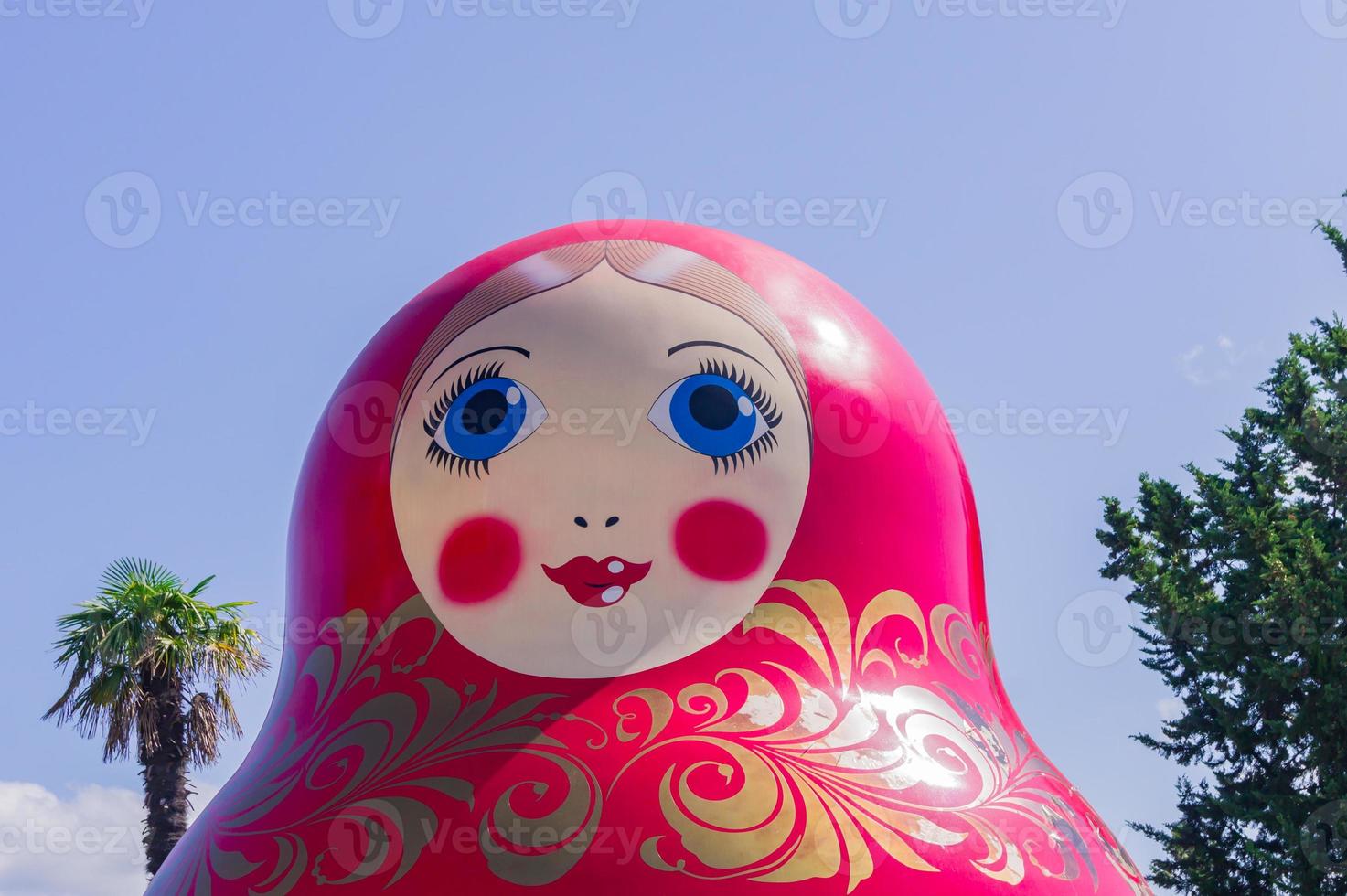 boneca matrioshka gigante russa no fundo do céu azul e palmeiras foto