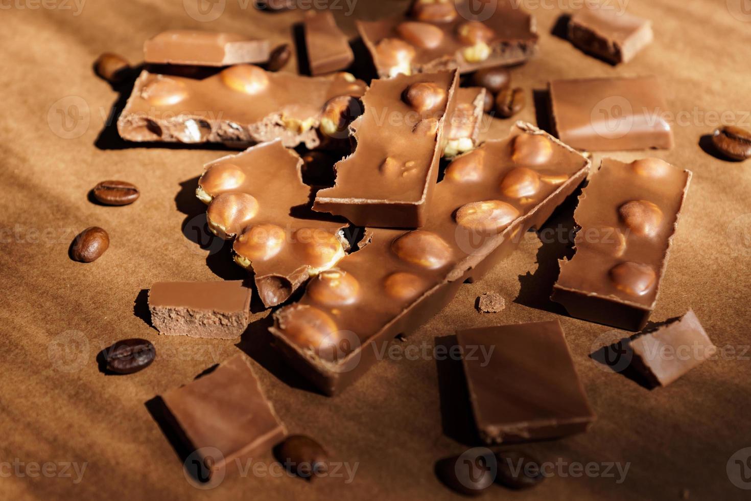 close-up de chocolate ao leite com avelãs em fundo marrom. sobremesa doce foto