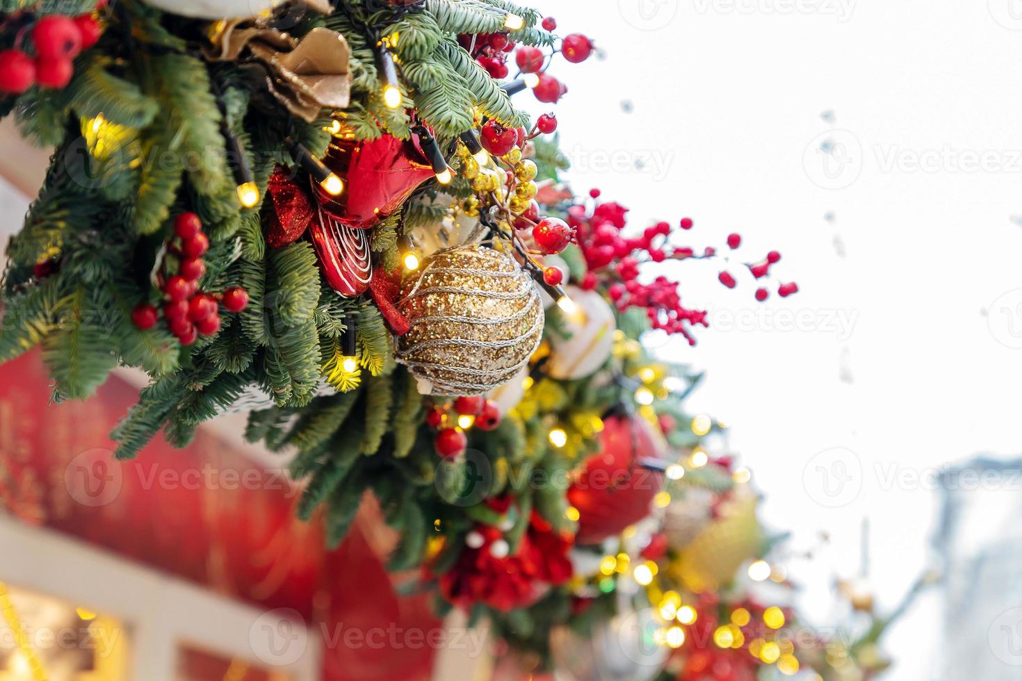 close-up de decoração de árvores de natal com brinquedos e guirlandas. decoração festiva da cidade durante as férias de inverno foto