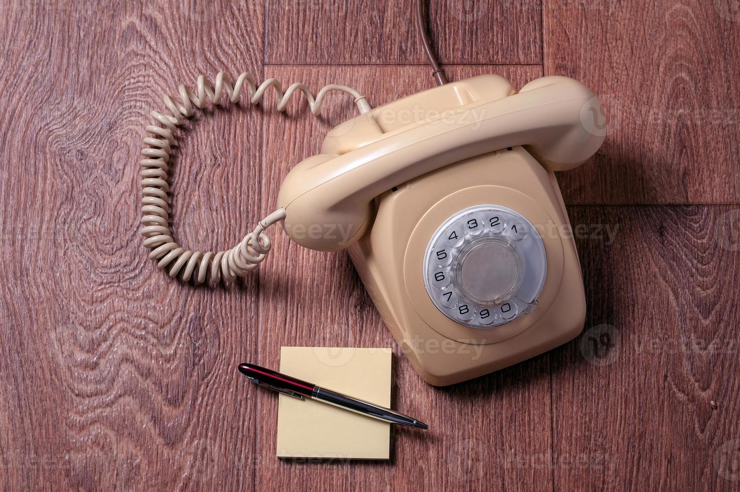 telefone retro na mesa de madeira em frente fundo gradiente foto