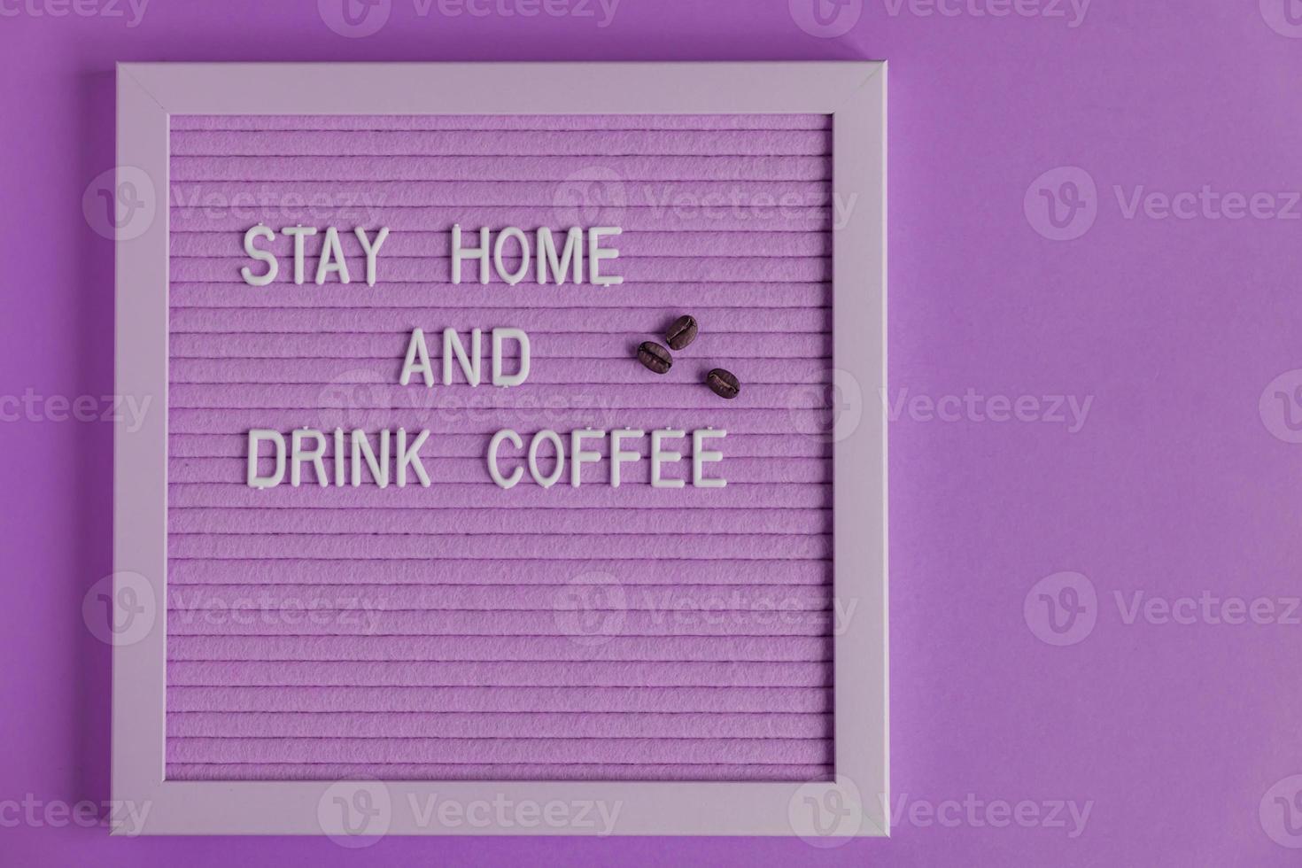 citar ficar em casa e beber café na placa decorativa roxa. decoratina com grãos de café. placa de tipografia para decoração de interiores. foto