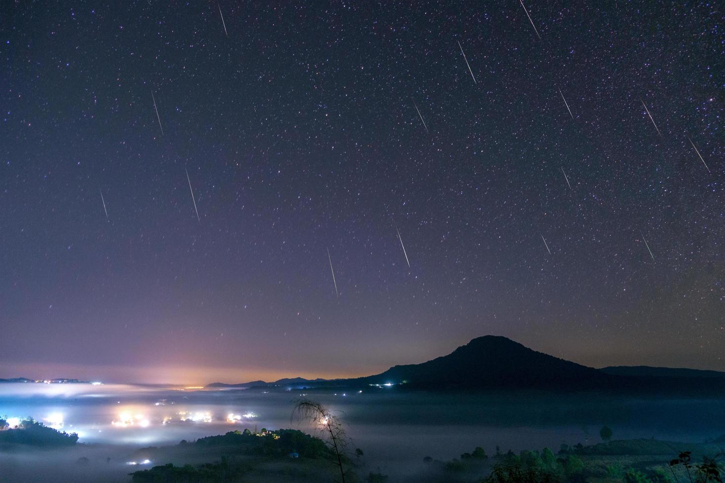 meteoro geminid no céu noturno com lua e nevoeiro no ponto de vista khao takhian ngo em khao-kho phetchabun, tailândia foto