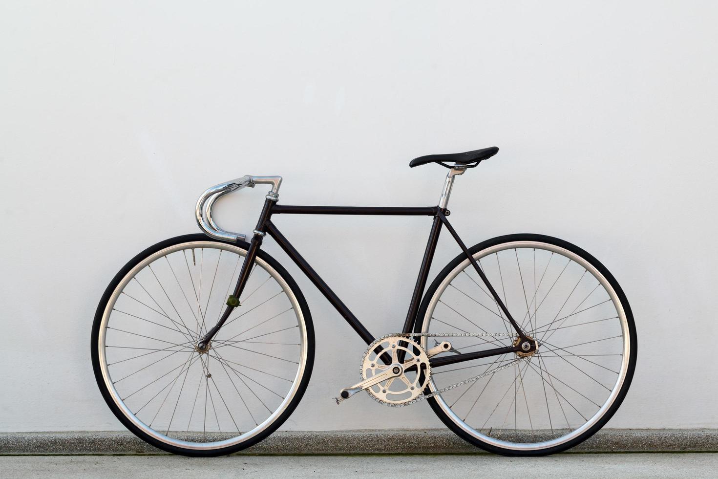 engrenagem fixa de bicicleta da cidade e parede de concreto foto