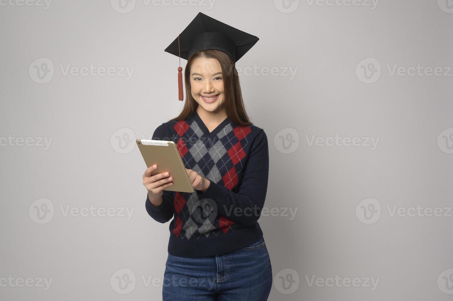 jovem mulher sorridente segurando o chapéu de formatura, educação e conceito universitário foto