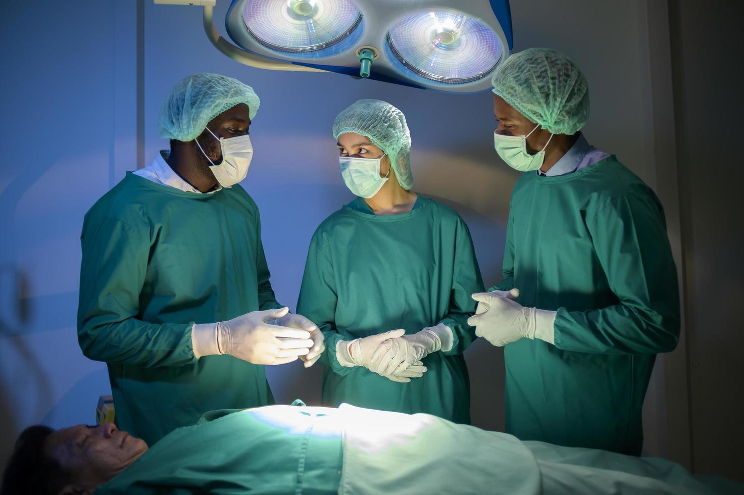 grupo de cirurgiões profissionais de raças mistas que operam na sala de cirurgia do hospital, conceito de cuidados de saúde. foto