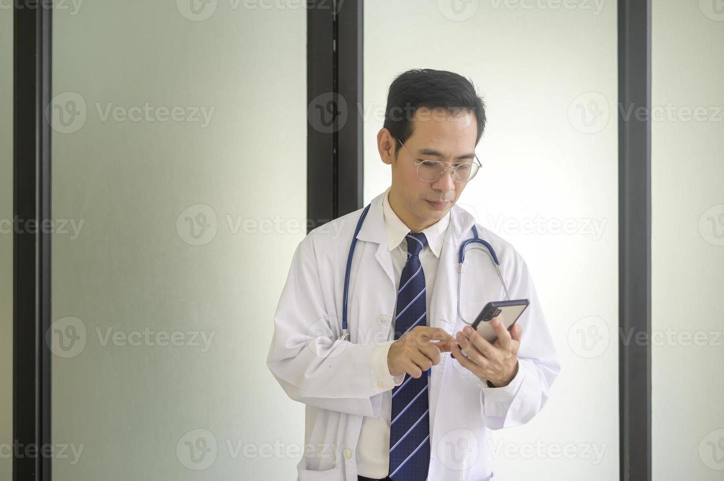 retrato de médico sorridente confiante vestindo jaleco branco no hospital foto