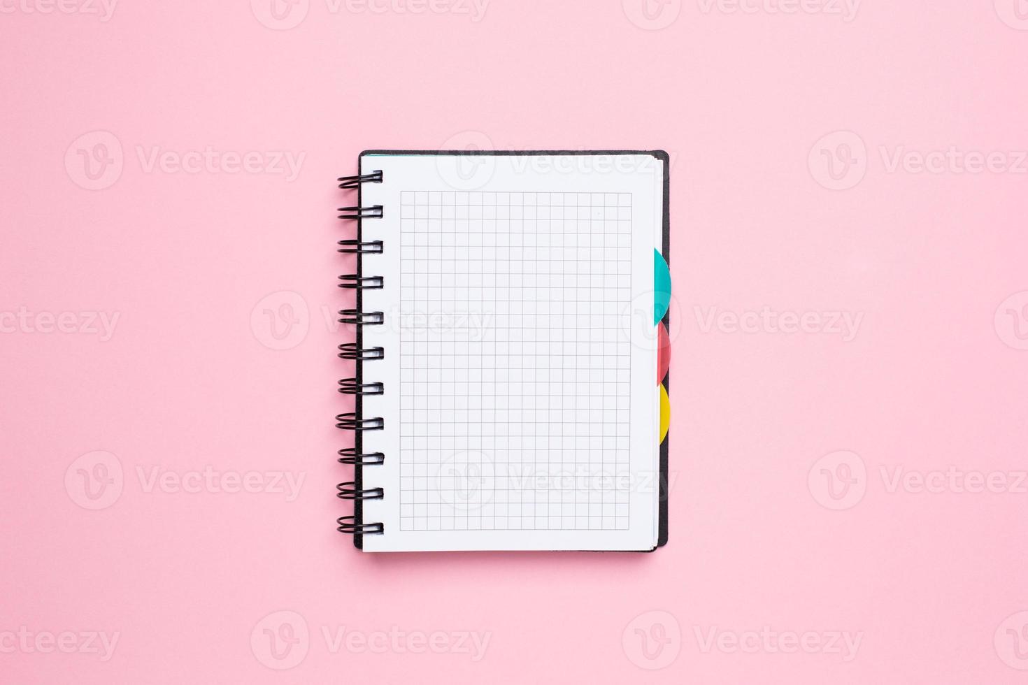 notebook em uma gaiola em um fundo rosa foto