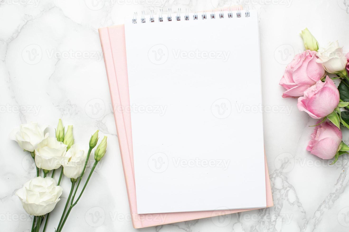 linda flor de rosas brancas e cor de rosa e notebook em fundo de mármore foto