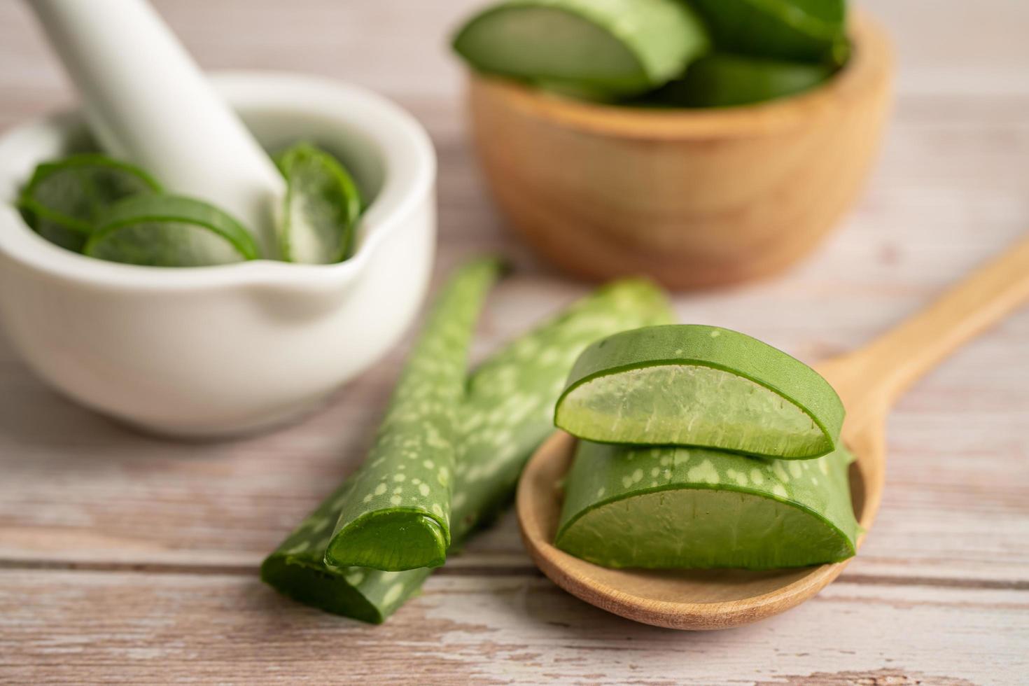 aloe vera com fatias em fundo de madeira, planta medicinal para saúde e beleza. foto