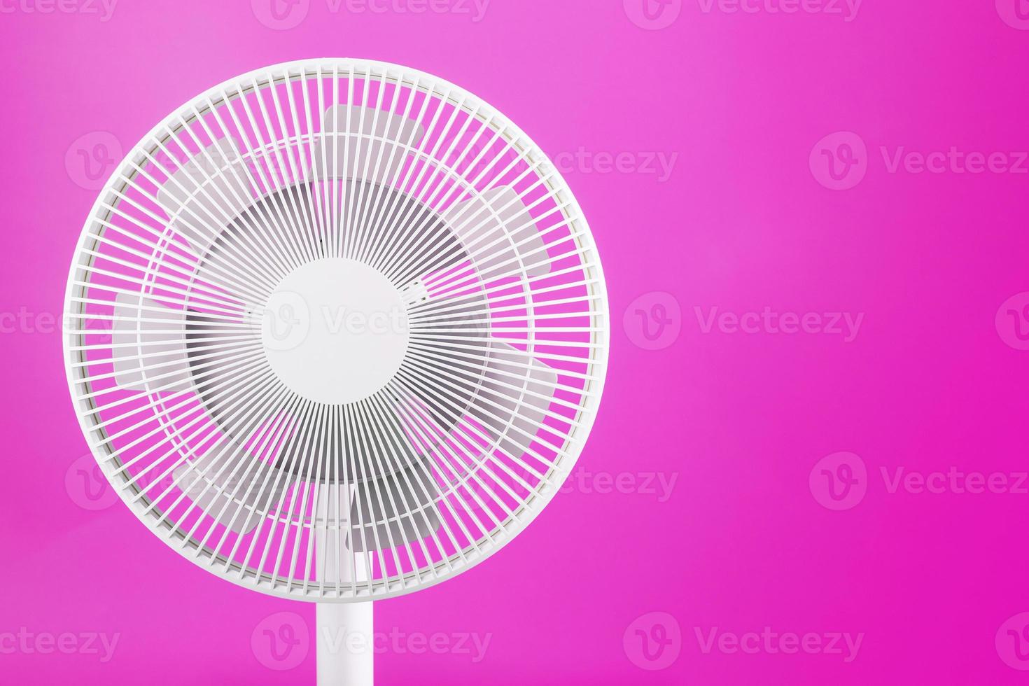 ventilador elétrico moderno branco para resfriar a sala em um fundo rosa. foto