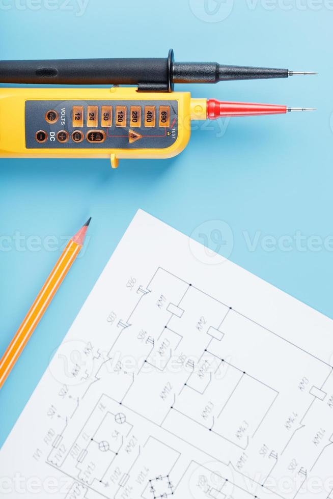 indicador de tensão de dois pólos com desenhos elétricos em um fundo azul. foto