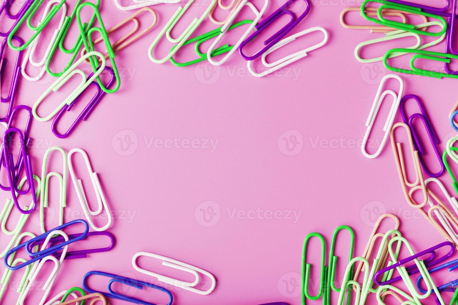 clipes de papel rzhivtkzhtsrbt multicoloridos espalhados em um fundo rosa foto